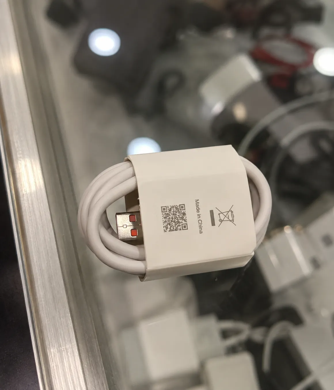 Xiaomi 120W fast charging cable coiled on a table, featuring a white cable and USB connector.